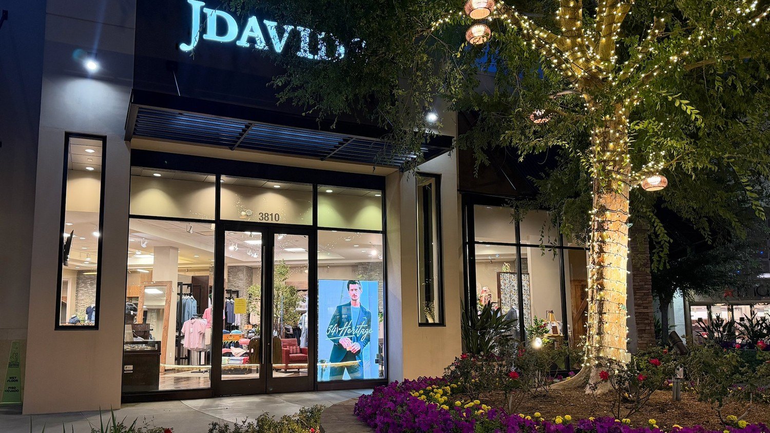 J. David's storefront at night with a Hudson Pictures LED video wall